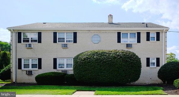 Front view of a two-story brick building with multiple windows and chimneys.