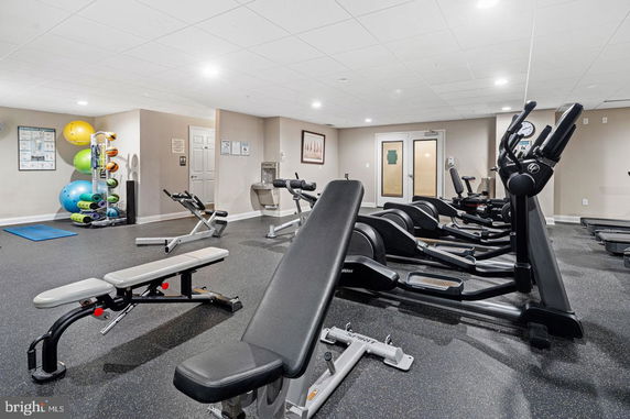 View of an indoor gym area with exercise equipment and yoga balls.