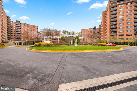 Front view of a large apartment complex with multiple stories and balconies.