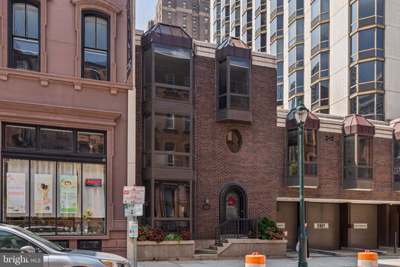 Front view of a multi-story brick building with large windows and garage entrances.