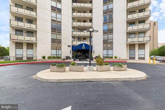 Front view of a multi-story building with balconies and entrance.