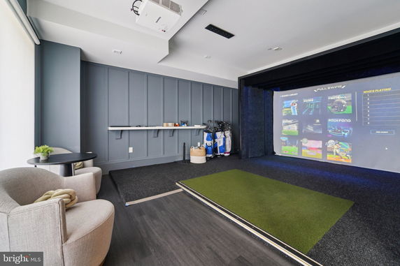 Indoor recreation room with a large screen for virtual games.
