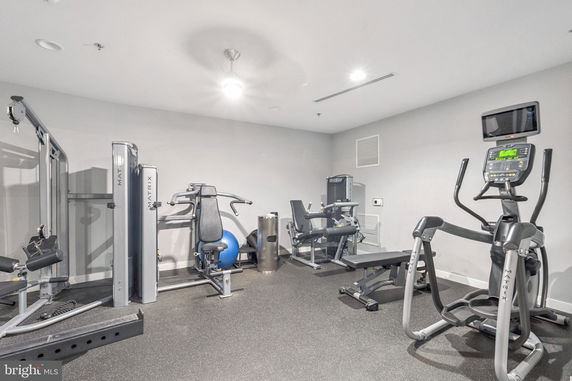 Indoor gym area with various exercise machines and equipment.