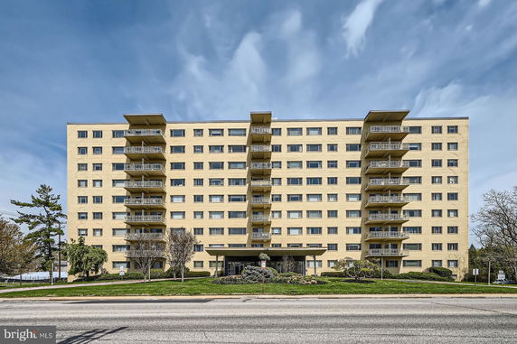 Front view of a multi-story apartment building with balconies.