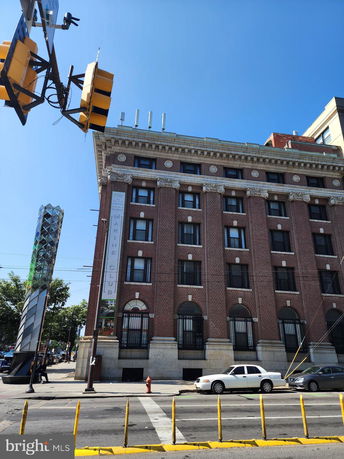 Front view of a multi-story brick building with decorative architectural elements.