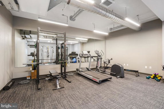 Indoor gym area with exercise equipment including treadmill and weights.