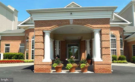 Front view of a brick building with white columns and large arched windows.