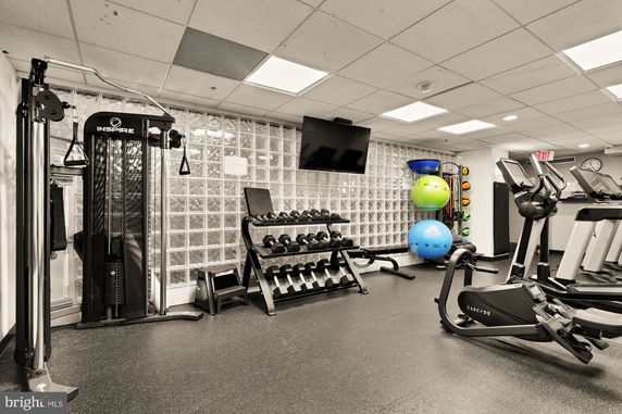 Indoor gym area with exercise equipment, including treadmills, weights, and exercise balls.