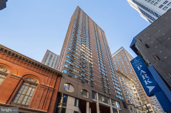 Front view of a tall multi-story building with a modern architectural design.