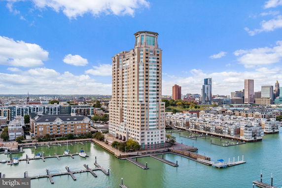 Front view of a tall multi-story building with large windows located by a waterfront.