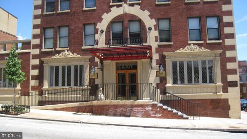 Front view of a multi-story building with a decorative entryway and brick facade.