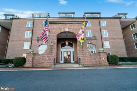 Front view of a multi-story brick building with flags.