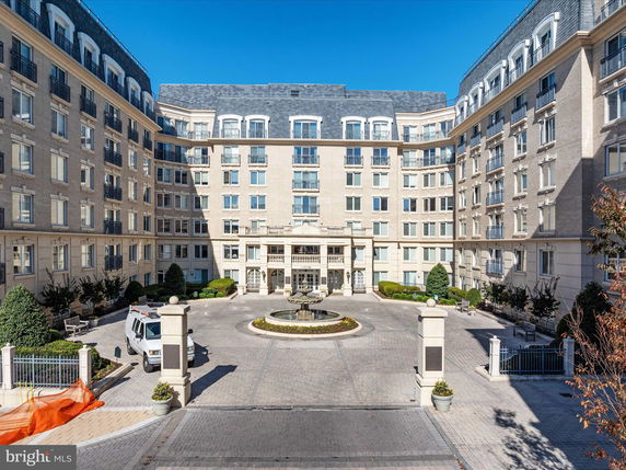 Front view of a large multi-story building with a central entrance and courtyard.