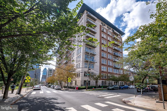 Front view of a multi-story residential building on a city street corner.