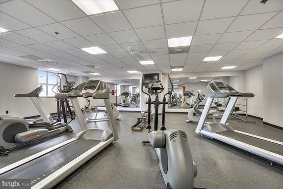 Interior view of a gym with exercise equipment including treadmills and elliptical machines.