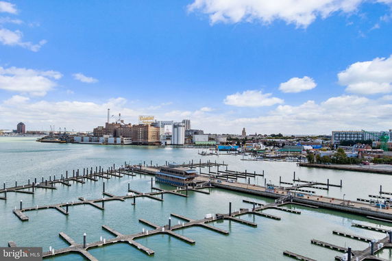 Wide-angle view of a harbor with docks and industrial buildings in the background.