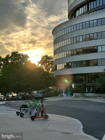 Side view of a rounded modern building with large windows.