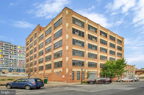 Front view of a multi-story brick building with large windows.