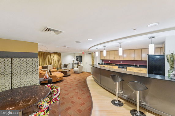 Interior view of a clubhouse with seating area and kitchen