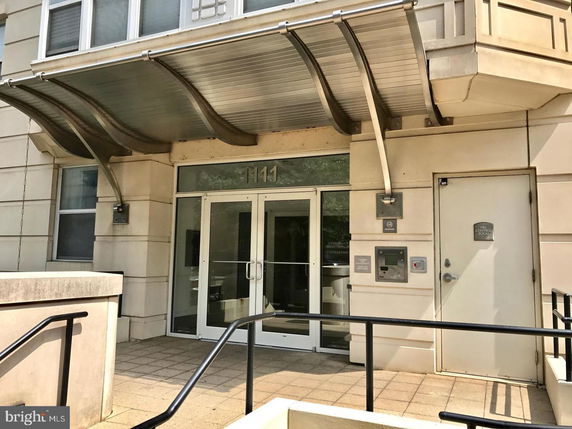 Entrance of a building with a modern glass door and metal awning.