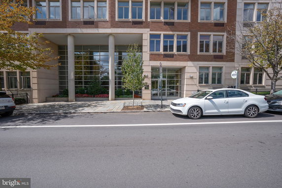 Front view of a multi-story building with large glass windows and brick facade.