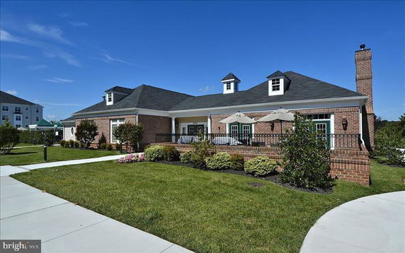 Front view of a single-story brick house with a covered porch and dormer windows.