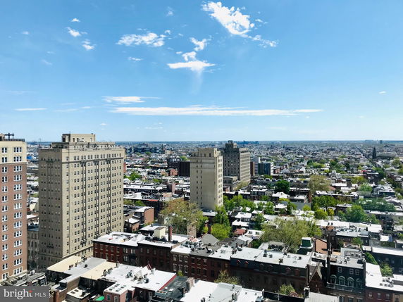 Panoramic view of a cityscape with tall buildings and horizon in the distance.