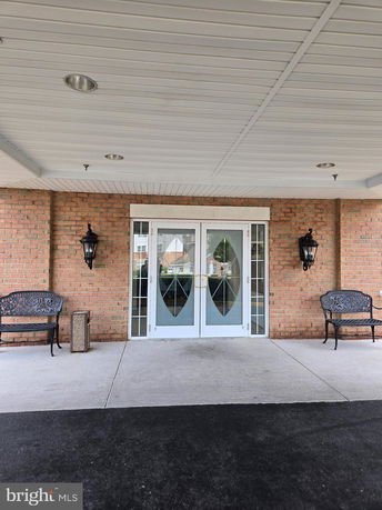 Front view of a building entrance with glass doors and brick walls.