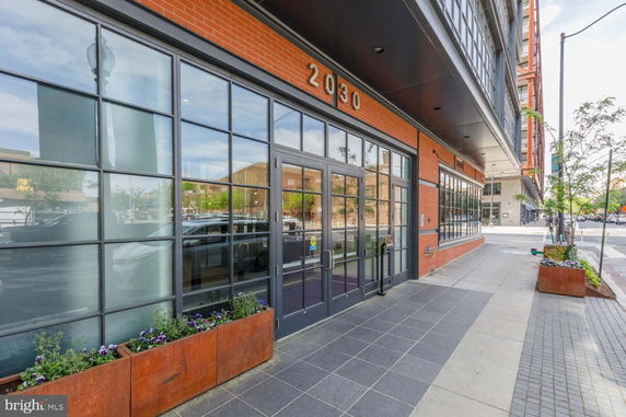 Front view of a modern commercial building with large glass windows and a brick facade.