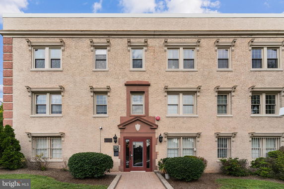 Front view of a three-story brick building with multiple windows and a central entrance.