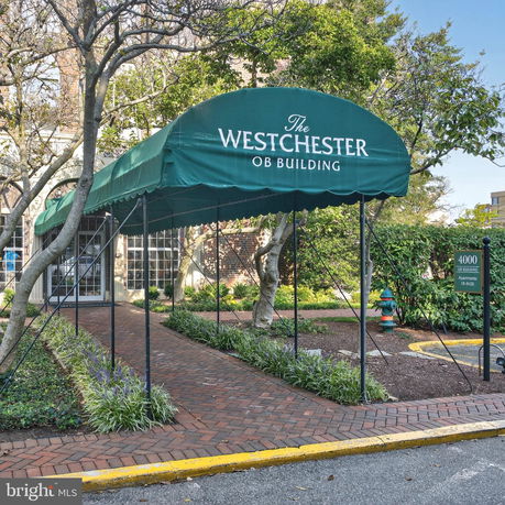 Front view of a building with a green canopy entrance.