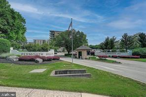 Front view of a multi-story building complex with a gated entrance.