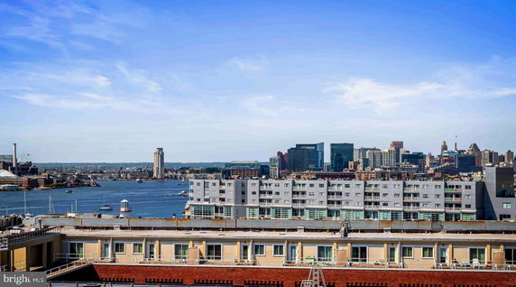 Panoramic view of a city skyline with water and buildings.