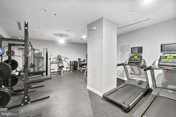 Indoor gym area with exercise equipment, including treadmills and weight machines.