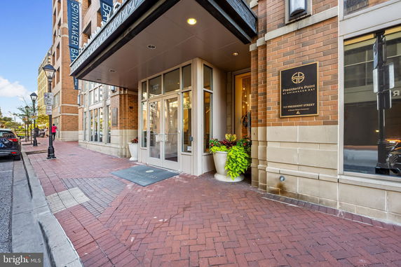 Front view of a building entrance with a glass door and brick exterior.