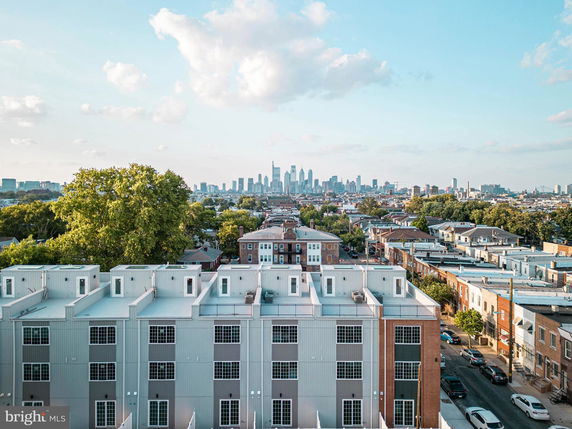 Panoramic view of a cityscape with a row of modern townhouses in the foreground.
