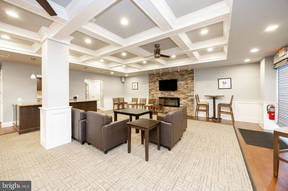 Interior view of a recreation room with seating area, TV, and bar counter.