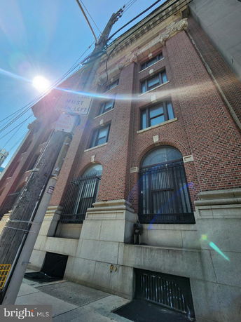 Front view of a multi-story building with brick facade and large windows.