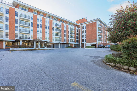 Front view of a multi-story apartment building with balconies.