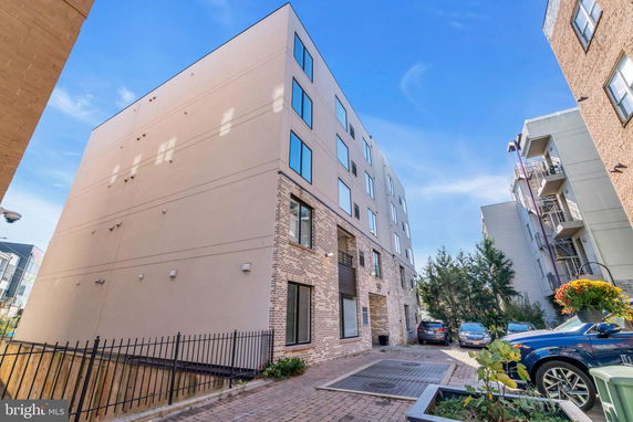 Front view of a modern multi-story building with brick and stucco facade.