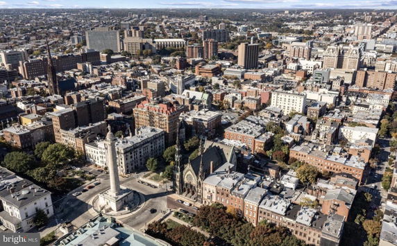 Aerial panoramic view of a cityscape with numerous buildings and a prominent monument in the foreground.