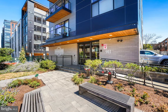 Front view of a modern multi-story building with glass and brick facade.