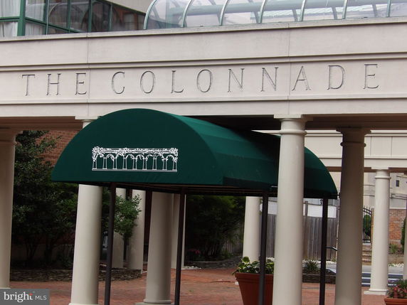 Entrance of a building with columns and green awning.