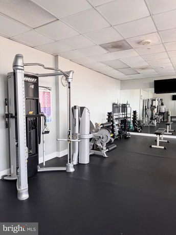Interior view of a gym with exercise equipment and weights.