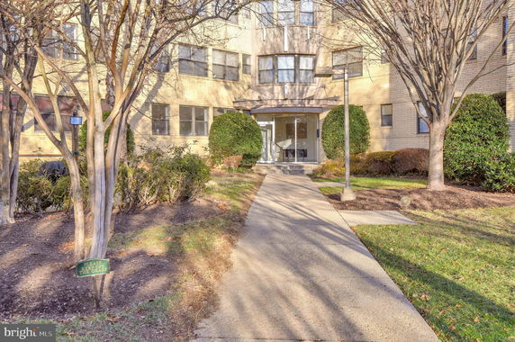 Front view of a multi-story residential building with a glass entrance.