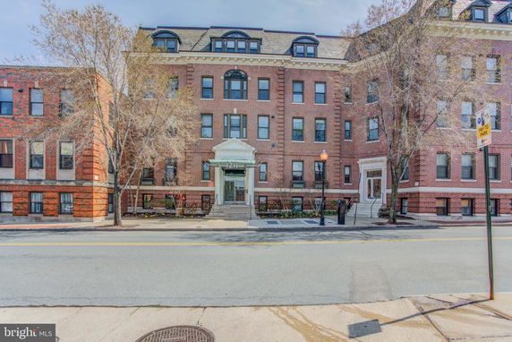 Front view of a multi-story brick building with numerous windows and a central entrance.
