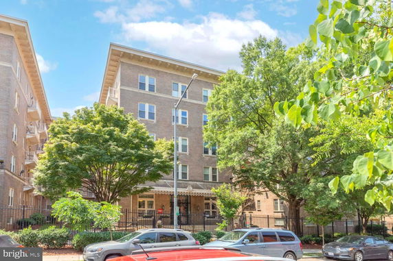 Front view of a multi-story brick building with balconies.