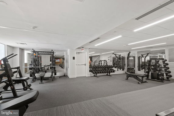 Interior view of a gym area with exercise equipment and weights.