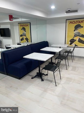 Indoor seating area with booth, tables, and chairs.