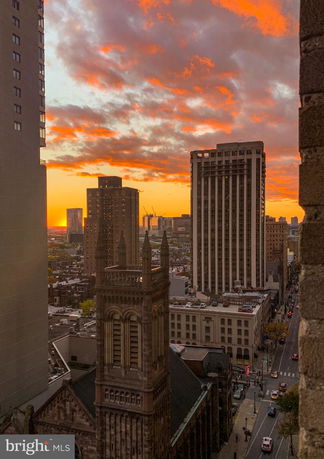 Panoramic view of skyscrapers and surrounding cityscape at sunset.